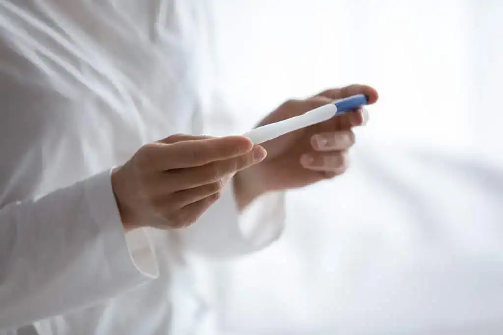Woman's hand holding a pregnancy test